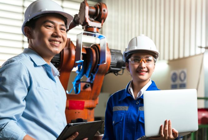 engineer cooperation Two asian male and female technician maintenance inspect relay robot system with tablet laptop to control quality operate process work heavy industry 4.0 manufacturing factory