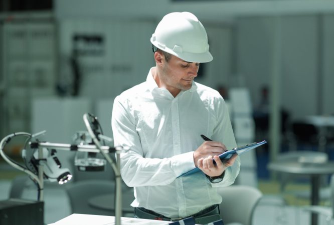 Technology Engineer Working in Factory. Holding check-list and supervising