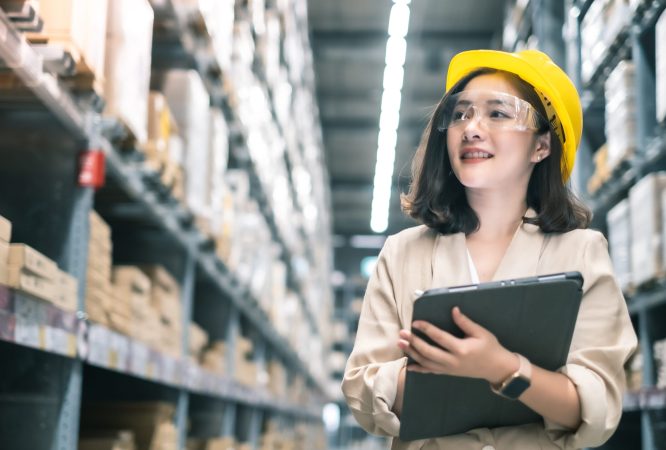 Pretty worker checking stock in the warehouse. Asian beautiful young woman worker of furniture store.Businesswoman using tablet in distribution stock.